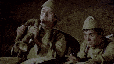 two men in military uniforms are playing a trumpet