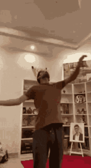 a man is dancing in a room with his arms outstretched