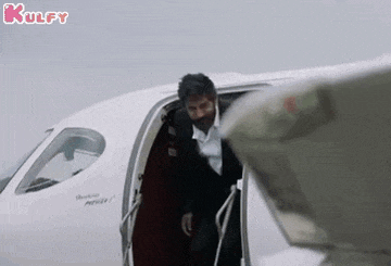 a man in a suit and tie is getting out of a private jet .