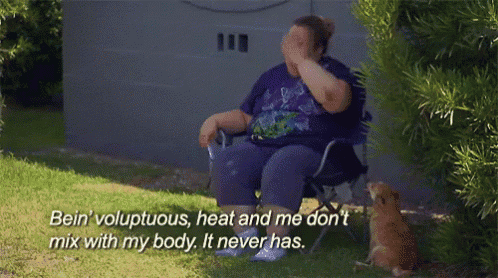 a woman sits in a chair with a cat and says bein voluptuous heat and me don 't mix with my body