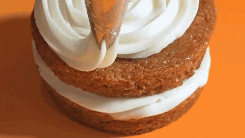 a close up of a cake with frosting being piped on it