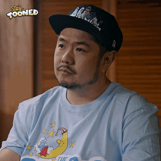 a man wearing a hat and a shirt that says stay tooned on it