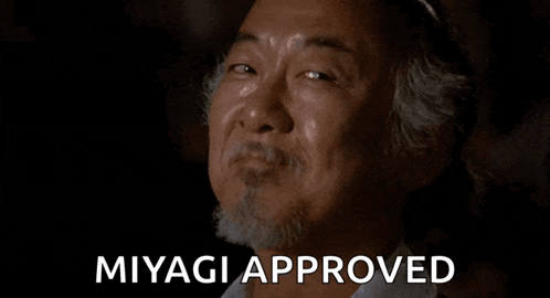 a man with a beard is smiling with the words `` miyagi approved '' behind him .