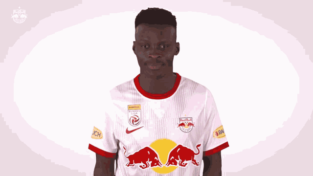 a man wearing a red bull jersey is dancing in front of a white background