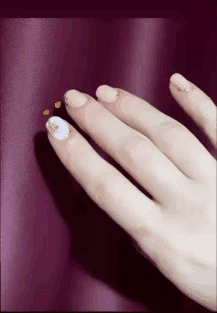a close up of a woman 's hand with a purple curtain in the background