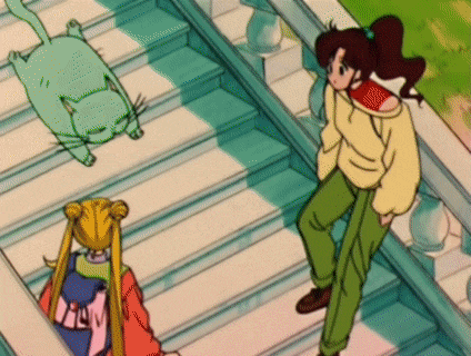 a girl standing on a set of stairs talking to a cat and another girl