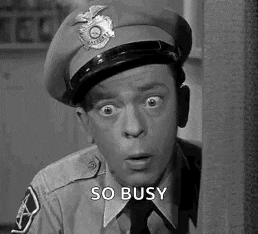 a black and white photo of a police officer in a hat and tie .