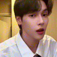 a young man in a white shirt and tie is looking at the camera .
