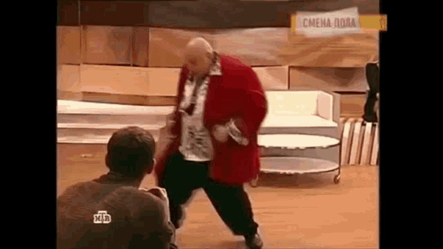 a man in a red coat is dancing on a stage in front of a sign that says ntv