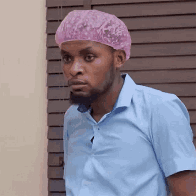 a man in a blue shirt and a pink shower cap