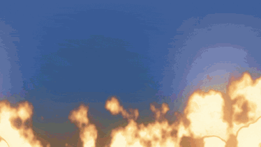 a blue sky with flames in the foreground and a few clouds in the background