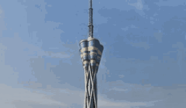 a tall tower against a blue sky with clouds .