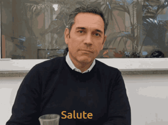 a man wearing a black sweater with salute written on it