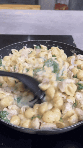 a pasta dish is being stirred with a fork in a pan