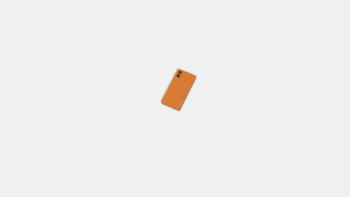 a shadow of a hand is cast on a white surface next to an orange cell phone