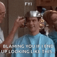 a man is getting his hair cut by a barber while wearing a metal bowl on his head .