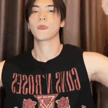 a man wearing a black tank top with the word guns n roses on it