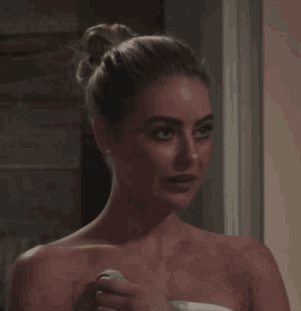 a woman without a shirt is holding a soap bar in her hand