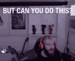 a man wearing headphones is sitting in front of a projector screen with the words `` but can you do this '' .
