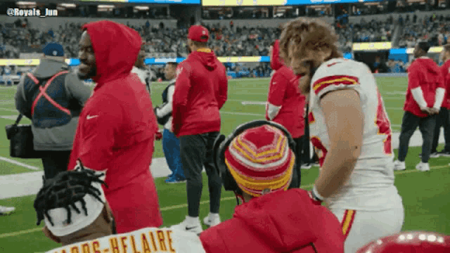 a football player wearing a red hoodie with the name helaire on the back