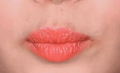a close up of a woman 's lips with red lipstick and a white teeth .