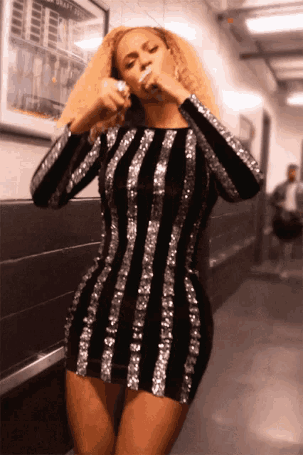 a woman in a black and silver striped dress