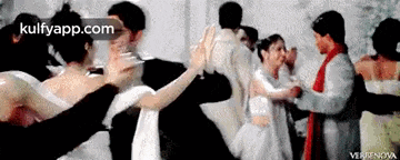 a group of people are dancing in a room with the words kulfyapp.com on the bottom of the screen .