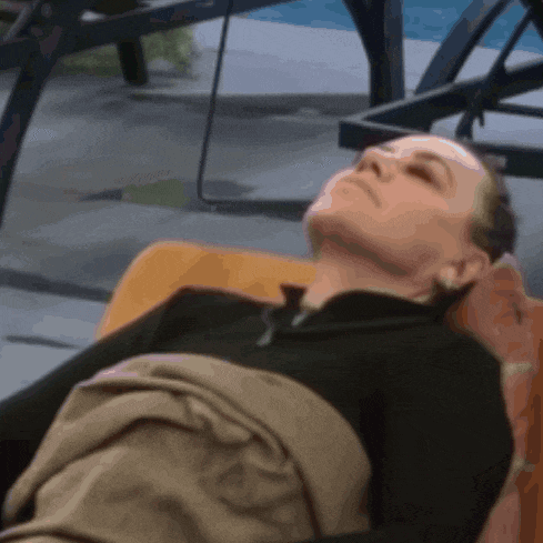 a woman in a black shirt is laying on a chair with her eyes closed