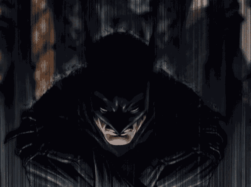 a close up of a man in a batman costume looking at the camera .