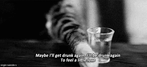 a black and white photo of a cat holding a glass of water .