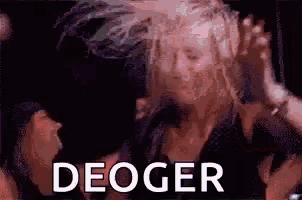 a woman is dancing in front of a microphone and the word deoger is written on the screen .