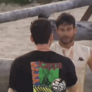 a man wearing a kappa t-shirt is talking to another man