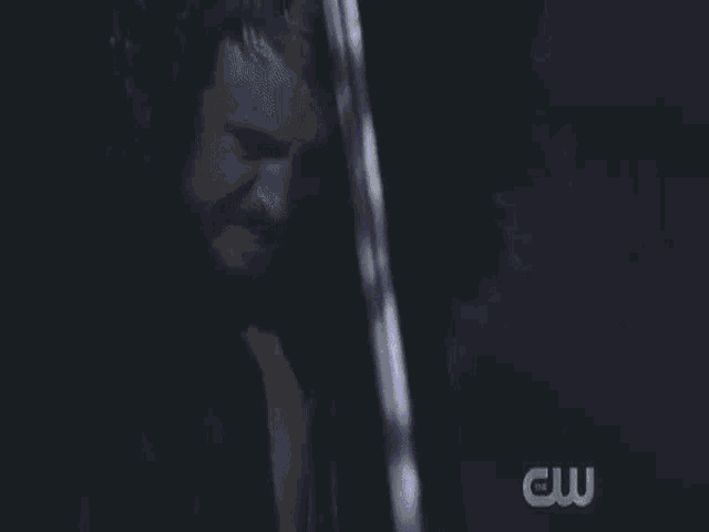 a man and a woman are looking into each other 's eyes in a dark room .