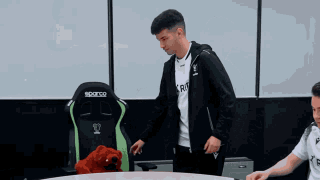 a man in a ref shirt holds a stuffed animal in his hand