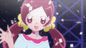 a girl with pink hair and yellow earrings is smiling and waving