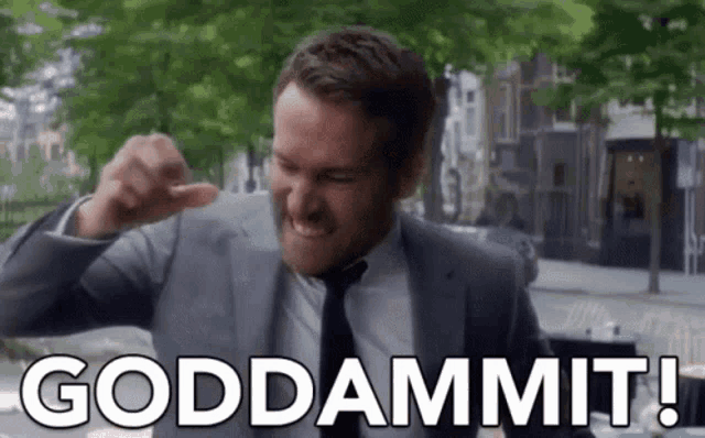 a man in a suit and tie is making a funny face and saying goddammit