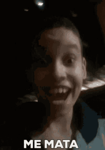 a young boy is making a funny face with his mouth open and the words `` me mata '' written below him .