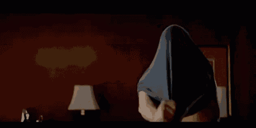 a shirtless man is standing in a bedroom next to a lamp and a mirror .