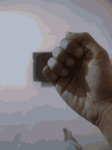 a close up of a person 's hand with a pink background