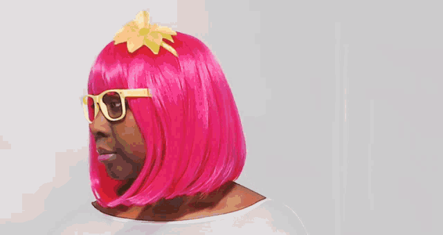 a woman wearing a pink wig and sunglasses makes a surprised face
