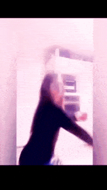 a blurry picture of a woman standing in front of a door .