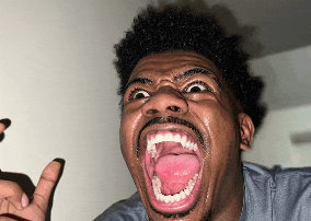 a man with a beard is making a funny face with his mouth wide open