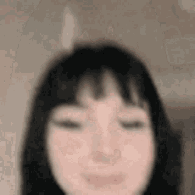 a close up of a woman 's face with her eyes closed and a smile on her face .