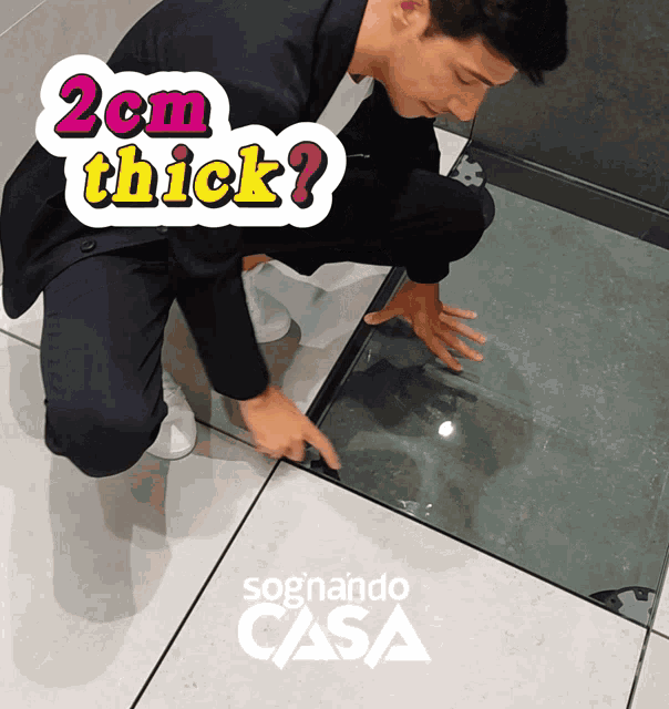 a man in a suit is kneeling on a tiled floor with a sticker that says " 2cm thick "