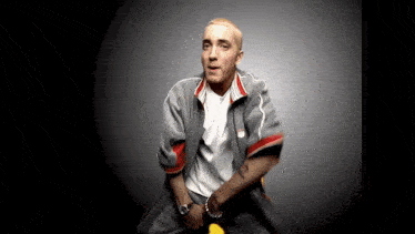 a man is sitting on a yellow chair wearing a grey jacket and a white shirt .