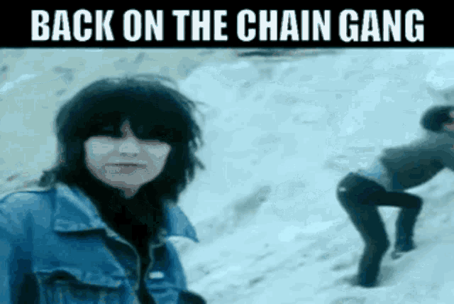 a woman in a denim jacket is standing in the snow with the words back on the chain gang written above her
