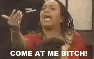 a woman is yelling at someone with the words `` come at me bitch '' written below her .