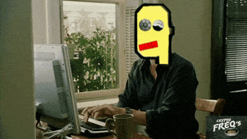 a man sits at a desk with a computer and a cup of coffee with a cartoon face on his face