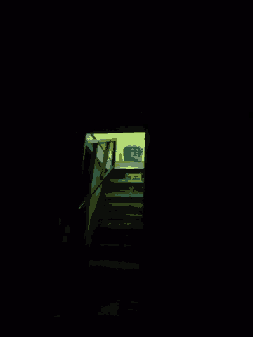 a dark room with a yellow door and a blue object on the wall
