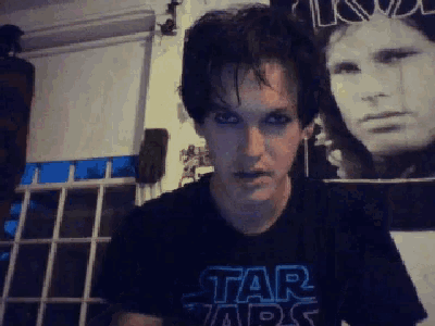 a man wearing a star wars shirt looks at the camera